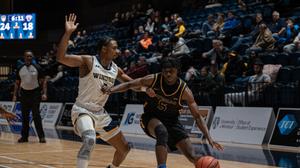 Men's basketball player drive to the hoop against Windsor Lancers
