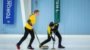 Warrior curlers sweep the rock as the head to the end